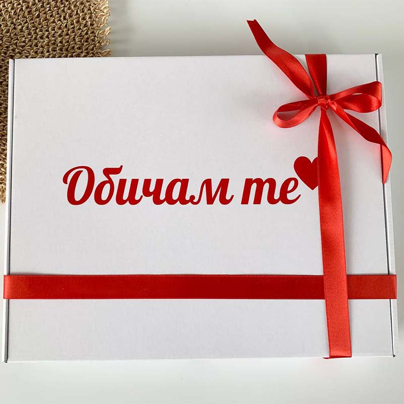 White gift box with red ribbon and text on a light gray background